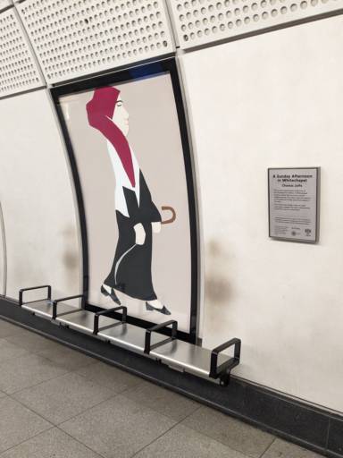 a photo of one of the artworks of the series "A Sunday Afternoon In Whitechapel" at platform level for the Elizabeth line at Whitechapel station. The artwork is large and embedded into the wall, and in front of it is a bench with 4 seats divided by middle bars. on the back of the seats not directly in front of the artwork, there are brown ghost-like figures left by commuters who sat there.